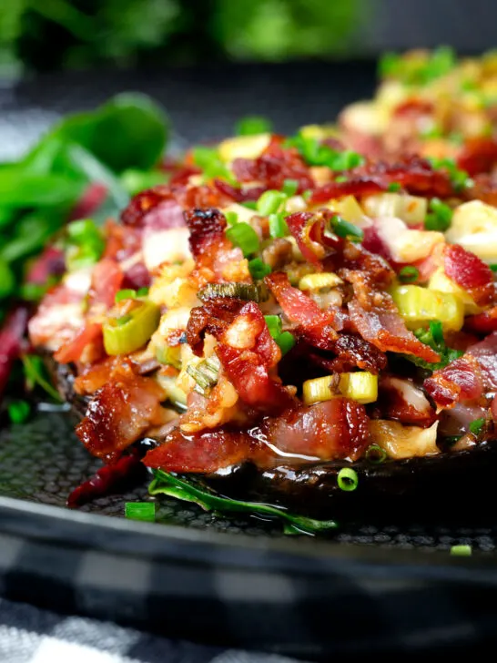 Close-up bacon stuffed mushrooms with Lancashire cheese and snipped chives.