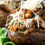 Close-up beef mince stuffed Portobello mushrooms with parmesan cheese featuring a title overlay.