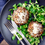 Overhead beef mince stuffed Portobello mushrooms with parmesan cheese and lambs lettuce.