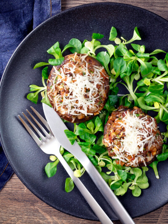 Overhead beef mince stuffed Portobello mushrooms with parmesan cheese and lambs lettuce.