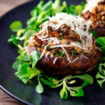 Beef mince stuffed Portobello mushrooms with parmesan cheese and lambs lettuce featuring a title overlay.