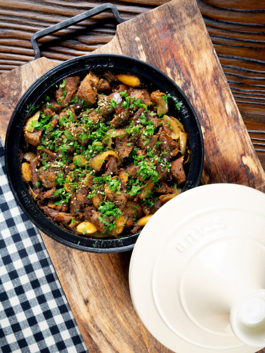 Overhead Moroccan lamb tagine with dates and almonds served in a tagine.