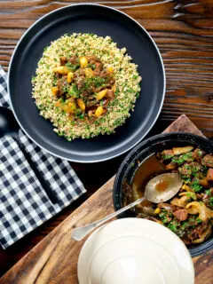 Overhead Moroccan lamb tagine served on a plate with buttered couscous.