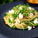 Pesto pasta with aged goat cheese and peas served with garlic bread.