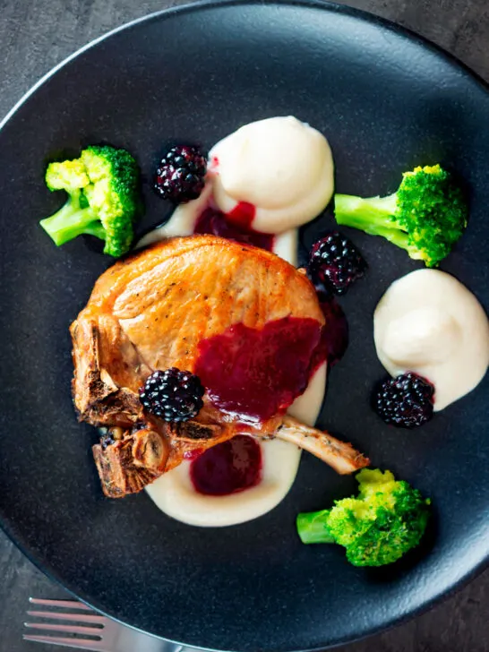 Overhead pork chops with a cider and fresh blackberry sauce with Jerusalem artichoke puree.