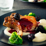 Pork chops with a cider and fresh blackberry sauce with Jerusalem artichoke puree.