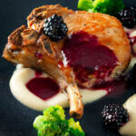 Close-up pork chops with a cider and fresh blackberry sauce with Jerusalem artichoke puree.
