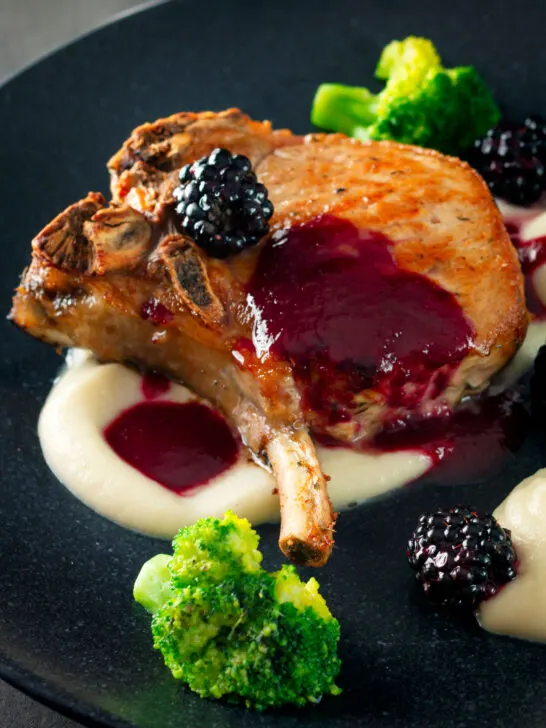 Close-up pork chops with a cider and fresh blackberry sauce with Jerusalem artichoke puree.