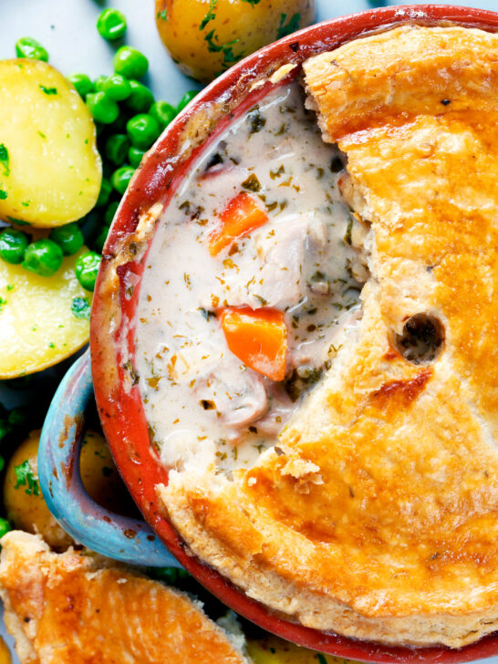 Overhead close up rabbit pot pie with a suet crust cut open to show creamy filling.