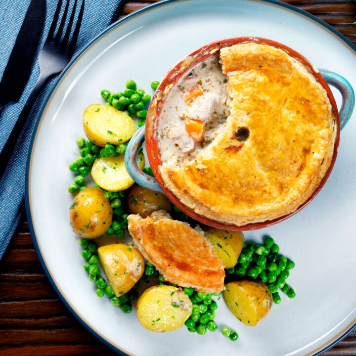 Rabbit pot pie with a suet pastry crust served with buttered herby potatoes and peas.