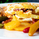 Close-up Hungarian layered potato bake, rakott krumpli served on a plate.