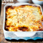 Hungarian layered potato bake, rakott krumpli served with pickles featuring a title overlay.