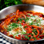 Chorizo shakshuka a baked in a tomato sauce with egg, pepper and onion.