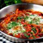 Chorizo shakshuka a baked in a tomato sauce with egg, pepper and onion featuring a title overlay.