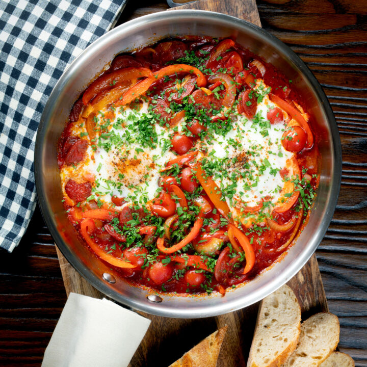 Shakshuka or shakshouka with chorizo sausage, peppers, tomatoes, and baked eggs.