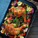 Overhead Spanish chicken and chorizo tray bake with peppers, onions and artichokes.