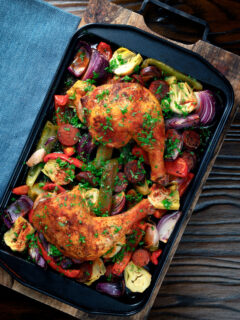 Overhead Spanish chicken and chorizo tray bake with peppers, onions and artichokes.