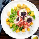 Overhead black pudding stuffed chicken with a mustard sauce, potatoes and runner beans.