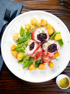 Overhead black pudding stuffed chicken with a mustard sauce, potatoes and runner beans.