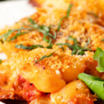 Close-up cheesy chicken and chorizo pasta bake served on a plate.