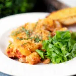 Cheesy chicken and chorizo pasta bake served on a plate.