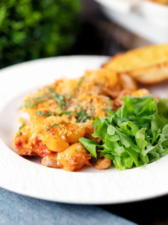 Cheesy chicken and chorizo pasta bake served on a plate.