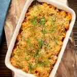 Overhead chicken and chorizo sausage pasta bake with a parmesan crust, featuring a title overlay.