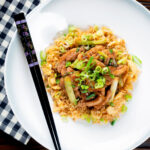 Overhead ginger chicken with garlic and spring onions served with egg fried rice.