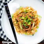 Overhead ginger chicken with garlic and spring onions served with egg fried rice, featuring a title overlay.