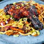 Chinese style char siu chicken leg served with sweet and sour noodles.