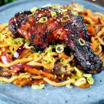 Chinese style char siu chicken leg served with sweet and sour noodles featuring a title overlay.