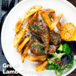 Overhead Greek lamb chops served with roasted garlic potatoes and seared lemon, featuring a title overlay.