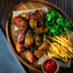 Sweet and spicy honey and sriracha glazed chicken wings served with fries.
