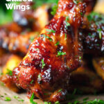 Close-up honey and sriracha glazed chicken wings, featuring a title overlay.