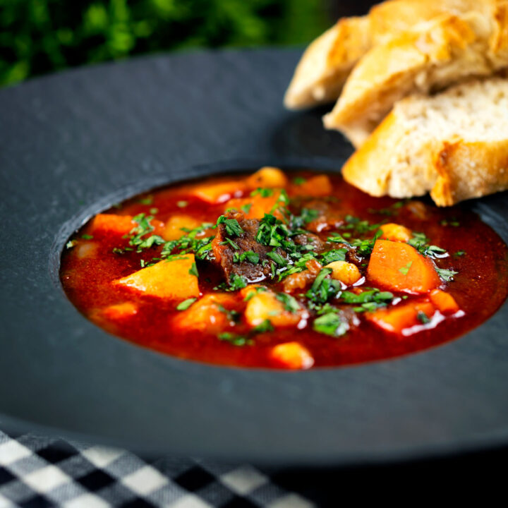 Gulyásleves a traditional Hungarian beef goulash soup served with bread.