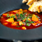 Traditional Hungarian goulash soup or Gulyásleves with csipetke (pasta), featuring a title overlay.