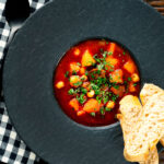 Overhead traditional Hungarian goulash soup or gulyásleves with csipetke (pasta).