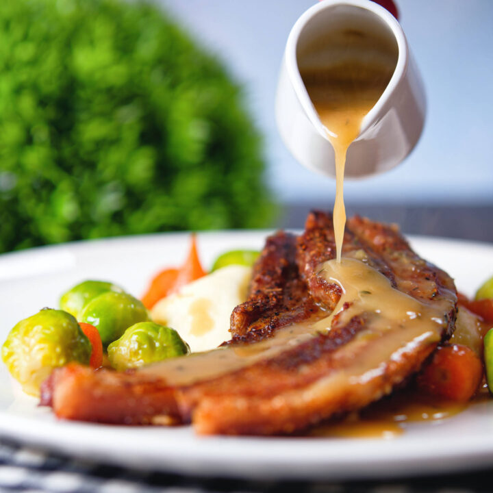 Crispy roast pork belly slices with a cider sauce, mashed potato, sprouts and carrots.