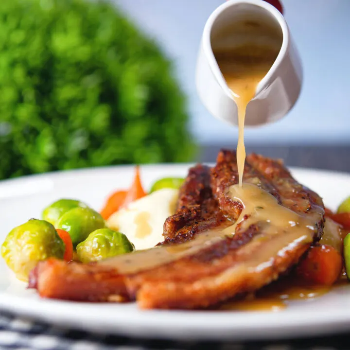 Crispy roast pork belly slices with a cider sauce, mashed potato, sprouts and carrots.