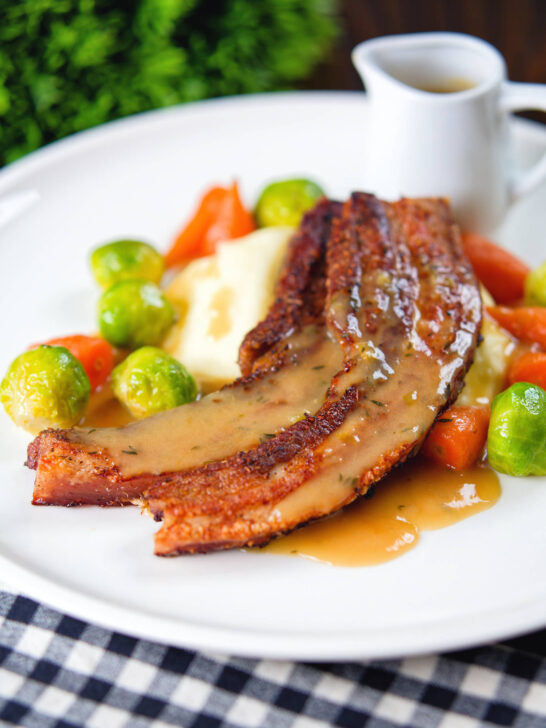 Crispy roast pork belly slices with a cider sauce, mashed potato and veggies.