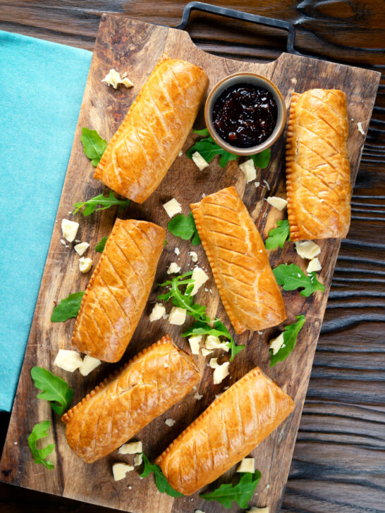 Overhead homemade pork and apple sausage rolls with golden hot crust pastry.