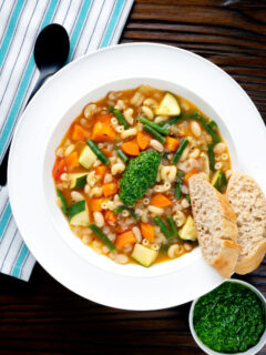 Overhead French soupe au pistou veggie soup served with bread.