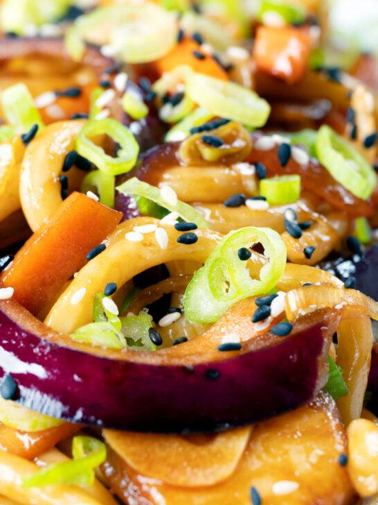 Close-up vegan sweet and sour vegetable and udon noodles stir fry.