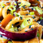 Close-up vegan sweet and sour vegetable and udon noodles stir fry, featuring a title overlay.