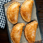Overhead British Cornish pasties on a baking tray.