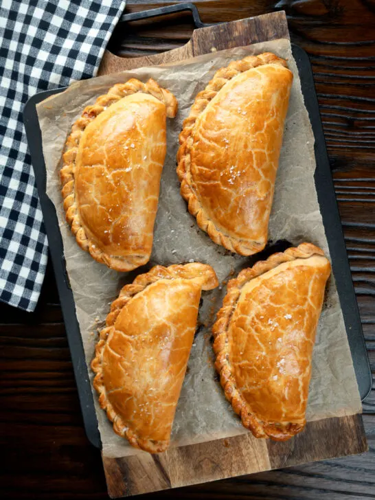 Overhead British Cornish pasties on a baking tray.