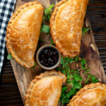 Overhead Traditional Cornish pasty served with chutney.