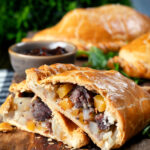 Traditional Cornish pasty cut open to show filling of beef, swede, potato and onions.