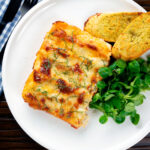Overhead vegetarian cauliflower and ricotta stuffed and baked cannelloni served on a plate.