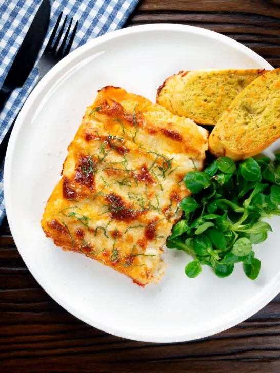 Overhead vegetarian cauliflower and ricotta stuffed and baked cannelloni served on a plate.